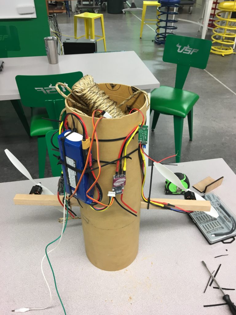 The steering system prototype as of this meeting. Shown is the battery, both propellers, some wiring, and paracord used for testing the system.